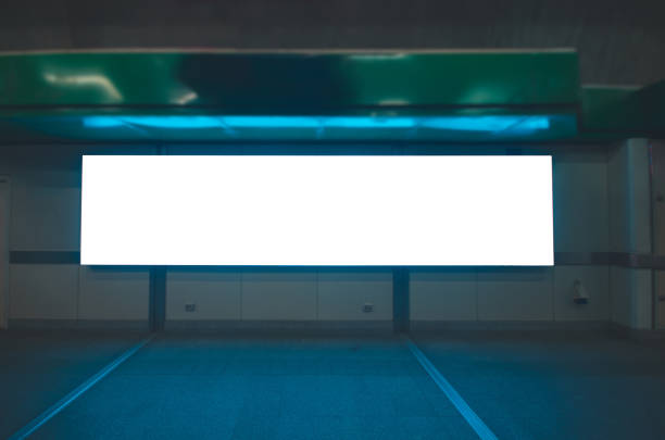 istock billboard big blank white LED screen horizontal outstanding in subway side pathway people walking to train underground for display advertisement text template promotion new brand indoor. 1083360626
