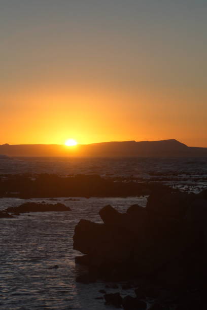 istock Sunrise silhouetting mountains over the bay 1083363082