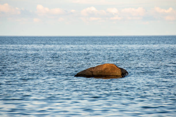 istock blue sky white clouds over calm body of water 1083363346