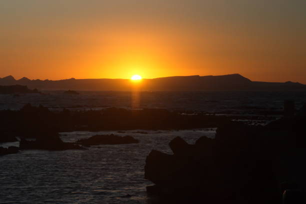 istock Sunrise silhouetting mountains over the bay 1083364578