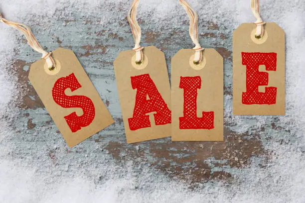 Hangtags with the word SALE on winter background