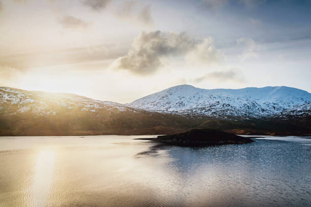 Scotland Loch Cluanie Sunset Scottish Highlands in Winter Sunset over Loch Cluanie Lake. Majestic snowcapped Scotland Winter Mountains in the background. Loch Cluanie in front of the Mountain Range. North West Scottish Highlands, Scotland, United Kingdom. fort augustus stock pictures, royalty-free photos & images