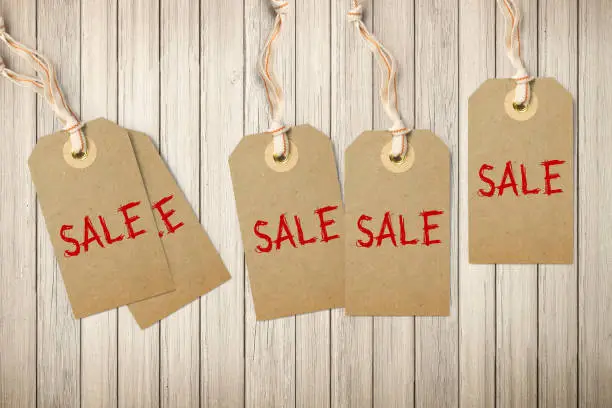 Hangtags with the word SALE on wooden background