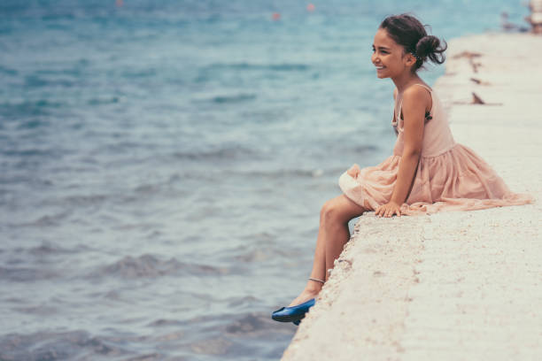 Cute kid on the quay enjoying the sea