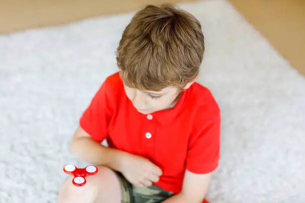 Photo of School kid playing with Tri Fidget Hand Spinner indoors