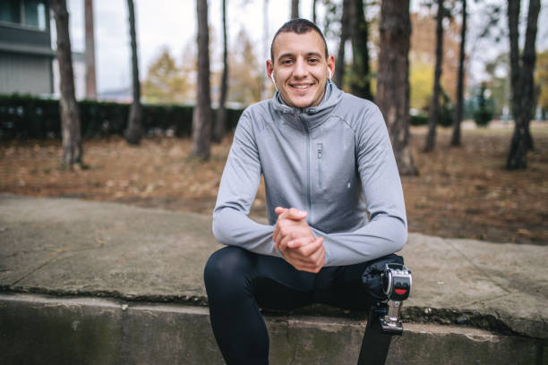 Young and athletic man with a artificial leg, exercising outdoors, living a healthy lifestyle recovering.