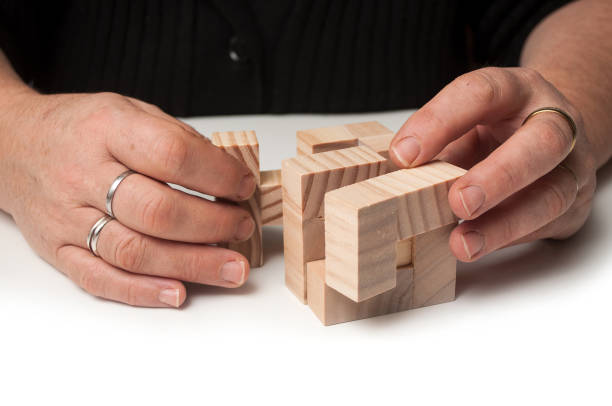istock woman hand with wooden puzzle  on white table background 1083381202