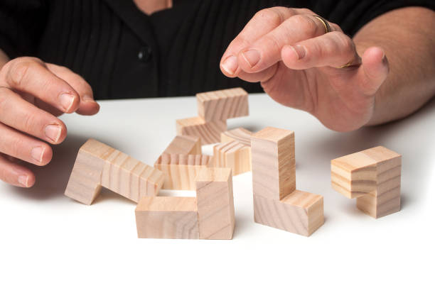 istock woman hand with wooden puzzle  on white table background 1083381332