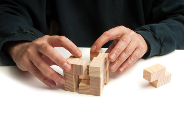 istock man hand with wooden puzzle  on white table background 1083383506