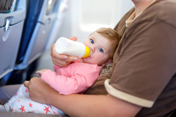 istock Father holding his baby daughter during flight on airplane going on vacations 1083385882