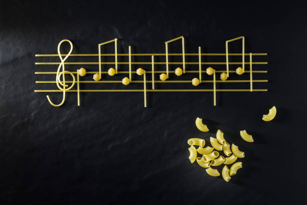 istock Musical Italian pasta in the form of notes, isolated on a black textural background. 1083387776