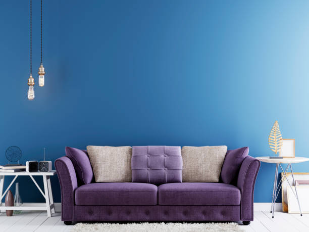 istock Empty wall for mock up on a blue wall in modern hipster interior with violet sofa and white table. 1083388780