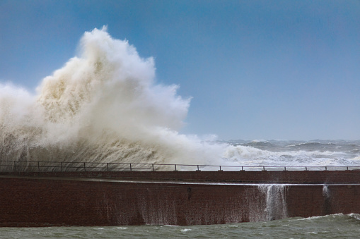 waves breaking on the pier at the entrance of the port of Scheveningen during a heavy storm; The Hague, Netherlands