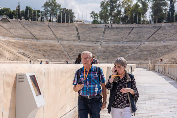 um casal em turnê no estádio panathinaiko em atenas, grécia - senior couple audio - fotografias e filmes do acervo