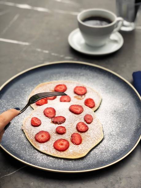 Delicious crepes with strawberries and coffee stock photo