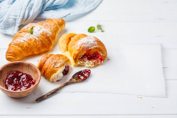 istock Croissants with berry jam on white wooden background. 1083411700