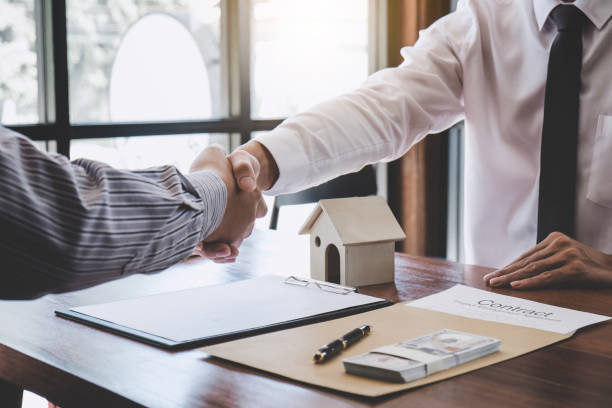 istock Real estate broker agent and customer shaking hands after signing contract documents for realty purchase, Bank employees congratulate, Concept mortgage loan approval 1083412358
