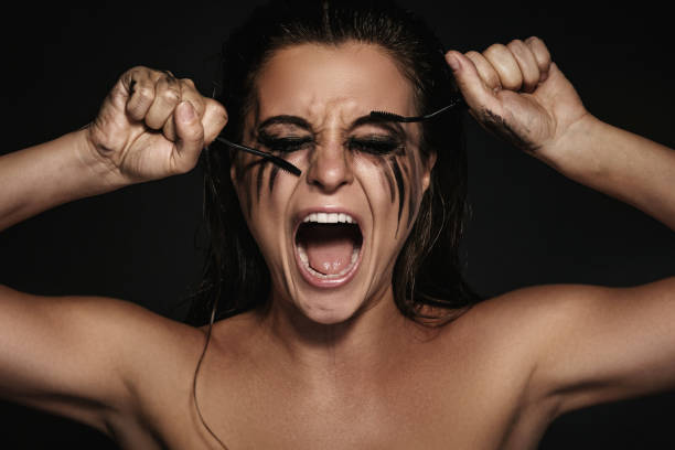 Woman with smudges of makeup on her face and broken mascara brushes Beautiful woman with smudges of makeup on her face and broken mascara brushes woman mascara smudged stock pictures, royalty-free photos & images