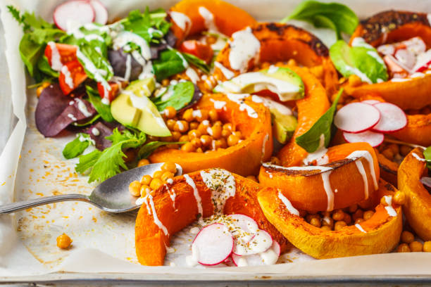 istock Baked pumpkin with chickpeas on a baking sheet with avocado, tahini and vegetables. 1083414978