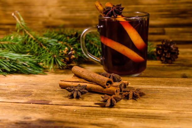 istock Cup of mulled wine with cinnamon and fir tree branches on wooden table 1083417126