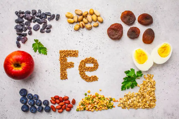 Healthy product sources of Fe. Top view, food background, iron ingredients: buckwheat, dried fruit, apple, eggs on a white background.