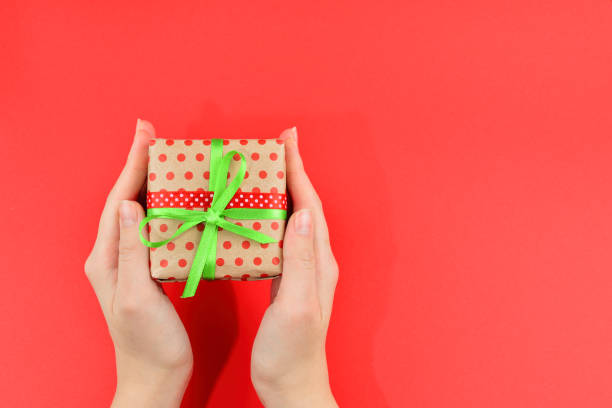 istock Present in woman hand on red background. 1083420288