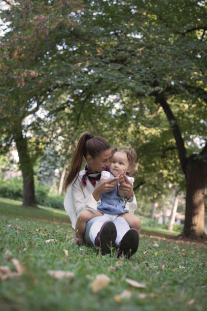 istock Mother with little daughter playing on green grass . 1083426290