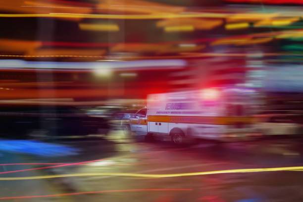 An ambulance speeding through traffic at nighttime