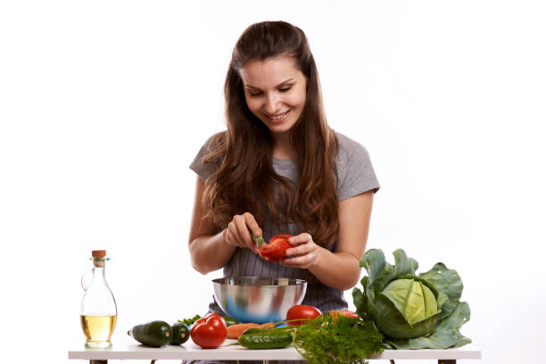 istock happy adult woman with various fresh vegetables on kitchen table looking at camera 1083429644