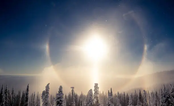Refraction of sunlight by ice crystals in the atmosphere.