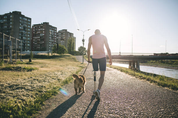 istock Amputee walking a dog by the river in summer 1083434246