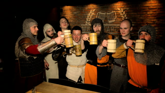 Medieval knights drink beer on dark background