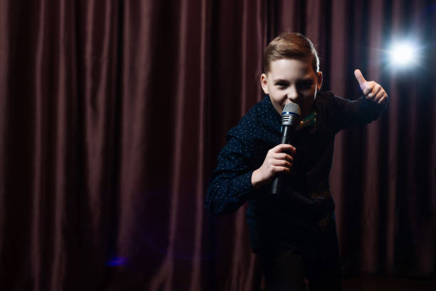 istock little boy singing in microphone. child in karaoke 1083441400