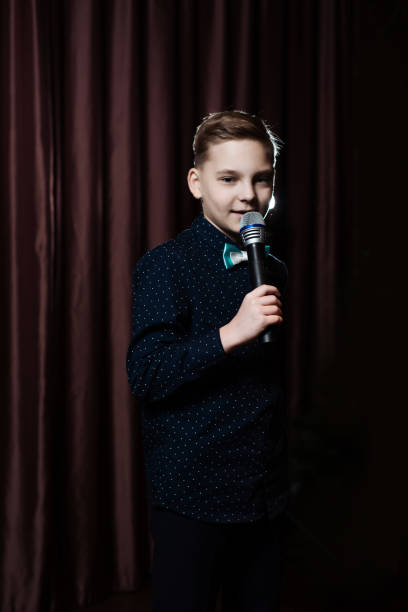 istock little boy singing in microphone. child in karaoke 1083441412