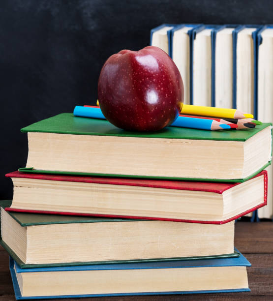 istock ripe red apple lying on a stack of books 1083441470