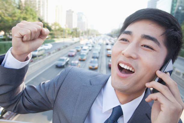 istock Chinese businessman on overpass talking on cell phone 1083441808