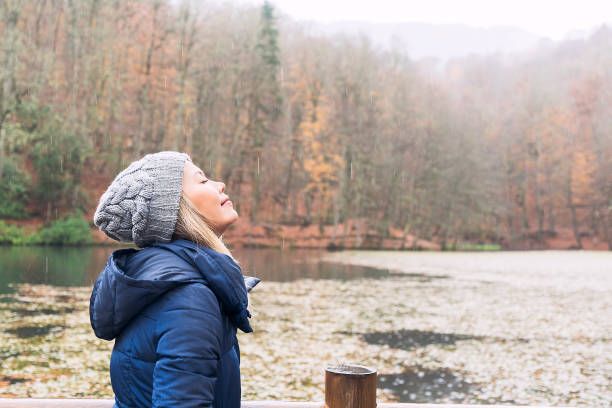mulher cheirando o ar no belo lago verde em dia chuvoso - meadow autumn hiking mountain - fotografias e filmes do acervo