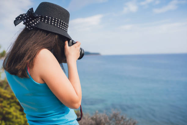 istock Woman making photos at seaside viewpoint 1083443162