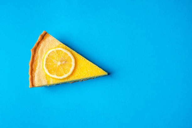 Lemon pie slice on a blue background. Above view and copy space