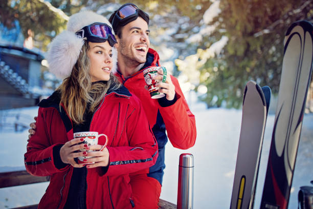 젊은 커플 포옹과 스키 후 뜨거운 차를 마시는 - romance skiing ski resort couple 뉴스 사진 이미지