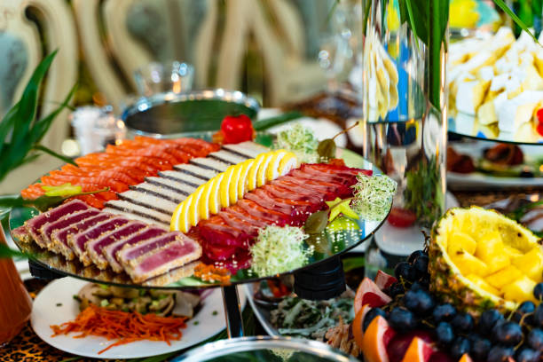 различные виды мяса, нарезанного лимоном в тарелке на праздничном столе. красиво украшенная тарелка с мясом и лимоном на специальной тарел� - beef carpaccio стоковые фото и изображения
