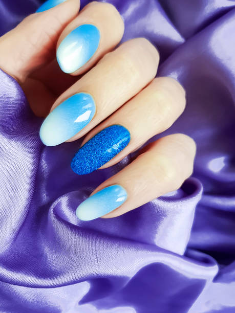 istock female hand beautiful manicure, silk fabric 1083460994