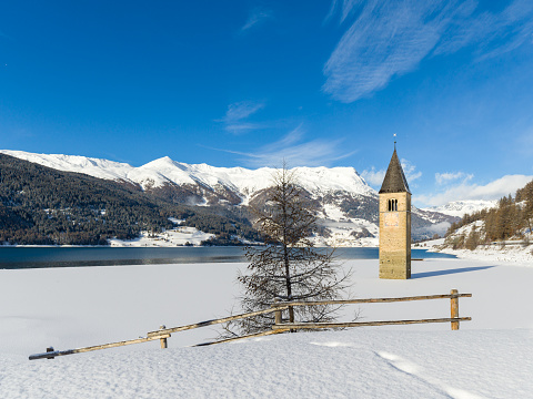 Sunken Church Tower in frozen lake near Graun on Resia Lake, South Tyrol