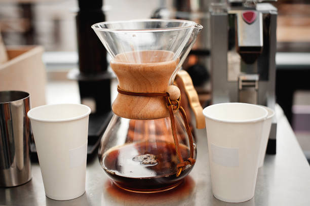 istock Kemeks and two paper disposable cups. Drip brewing coffee. 1083464290
