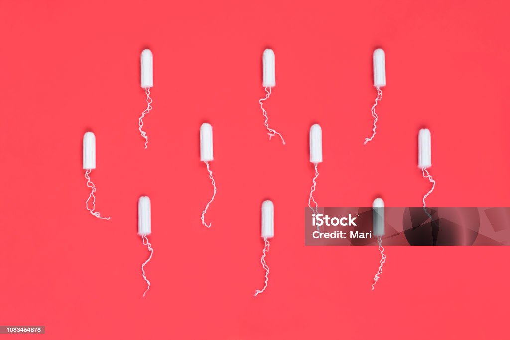 Menstrual period concept. Woman hygiene protection. Cotton tampons on red background. Top view, flat lay. Tampon Stock Photo
