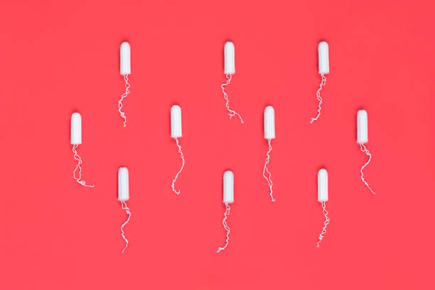 conceito do período menstrual. proteção de higiene da mulher. tampões de algodão no fundo vermelho. vista superior, plana leiga. - tampon - fotografias e filmes do acervo