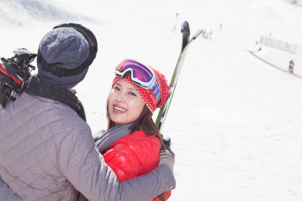 istock Chinese couple standing on ski slope with skis 1083472266