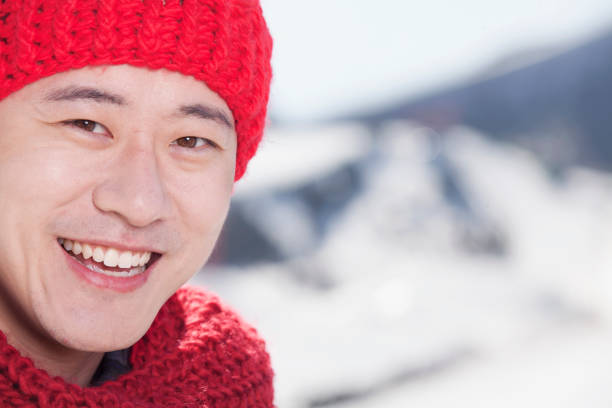Smiling Chinese man in red scarf and cap
