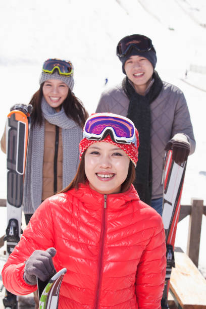 istock Chinese friends standing on ski slope with skis 1083472338