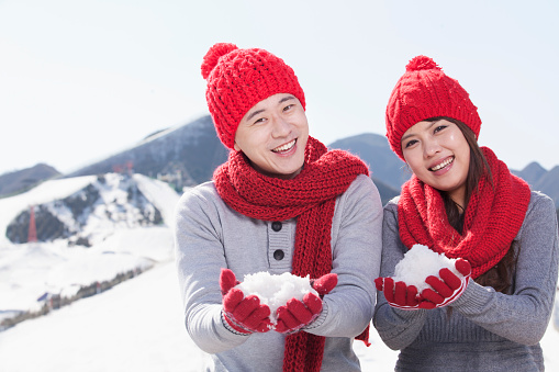 Chinese couple in snow wearing scarves and caps